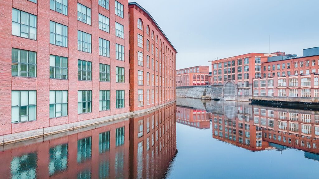 Rode bakstenen fabrieksgebouwen van Finlayson weerspiegeld in het Tammerkoski water